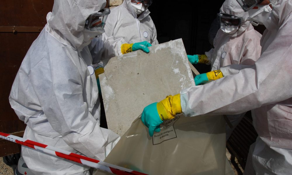 Dangerous work Staff removing some asbestos in a post of transformer